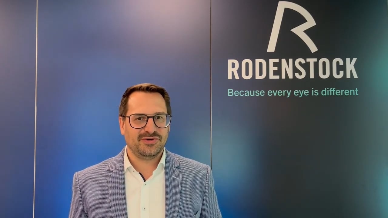 Rodenstock-Mitarbeiter vor Firmenlogo 