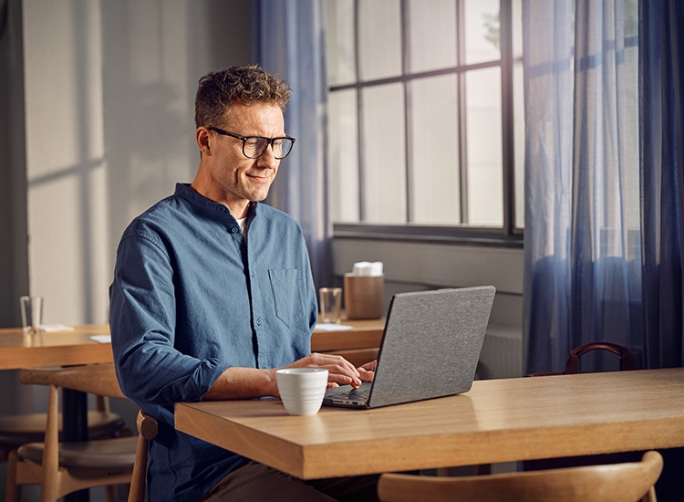 Ein Mann sitzt am Laptop und arbeitet 