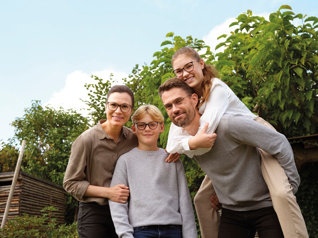Familie mit Brille schaut gemeinsam in die Kamera 