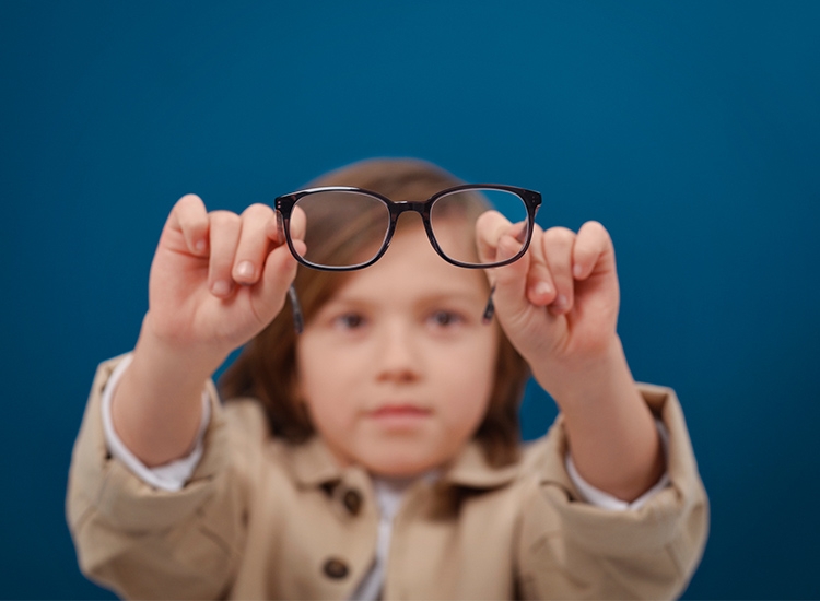 Junge hält MyCon-Kinderbrille vor sich in die Kamera 