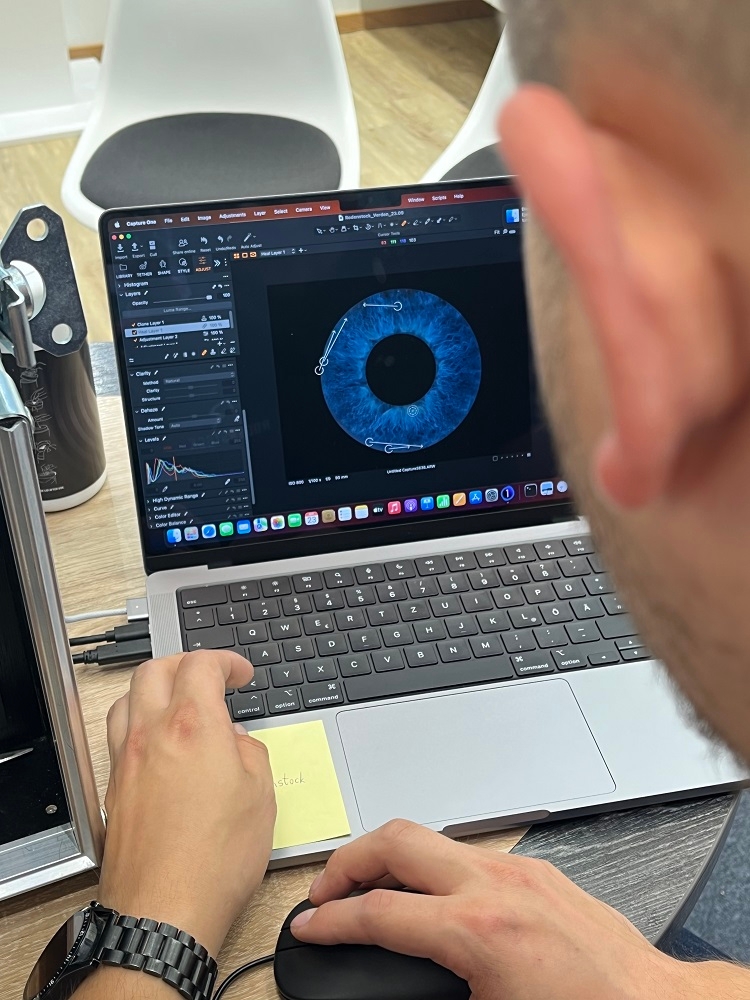 Ein Mitarbeiter betrachtet einen Iris-Scan am Laptop 