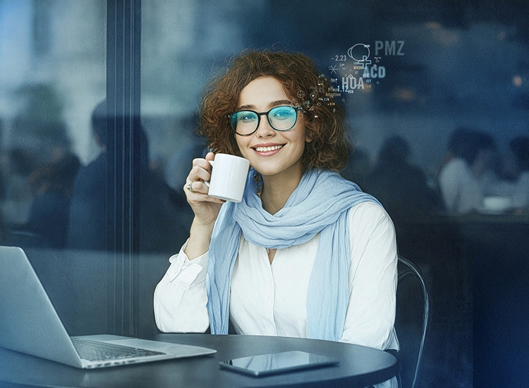 Frau sitzt am Schreibtisch und trinkt Kaffee 